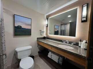 This well-appointed bathroom features a spacious vanity with a granite countertop and a modern undermount sink, perfect for your morning routine.