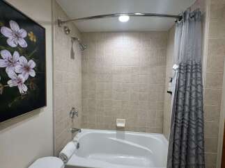 Step into this beautifully appointed bathroom, featuring a pristine white bathtub perfect for a relaxing soak.