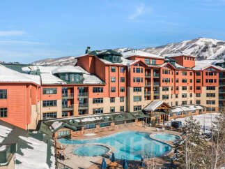 Experience luxury mountain living in this stunning resort property, featuring a heated outdoor pool and hot tub perfect for year-round enjoyment.