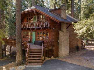 Experience the charm of this rustic log cabin nestled amongst tall pine trees.