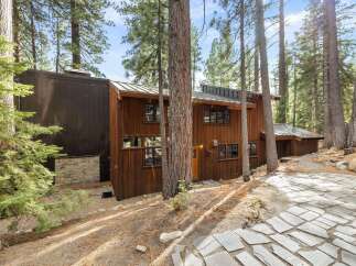 Nestled amidst towering pine trees, this stunning multi-level home offers a unique blend of rustic charm and modern design.
