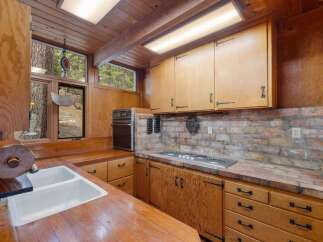 Experience rustic charm in this cozy kitchen, featuring warm wooden cabinetry and countertops that exude natural beauty.