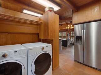 This laundry room boasts a full-size Whirlpool washer and dryer set, perfect for handling family-sized loads.