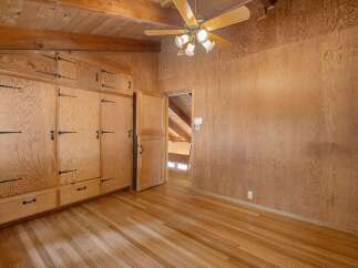 Step into a charming room featuring warm wood paneling and a stunning built-in cabinet system with intricate hardware.