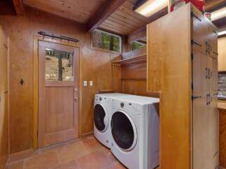 This charming laundry room features a full-size white washer and dryer set, perfect for handling family-sized loads.