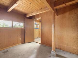 This room features warm, wood-paneled walls and a wood-slat ceiling with exposed beams, creating a rustic and natural aesthetic.