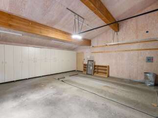 This spacious garage offers ample storage with a long wall of built-in cabinets, perfect for organizing tools and equipment.