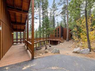 Experience rustic charm and modern design in this stunning wooden home nestled among tall pine trees.