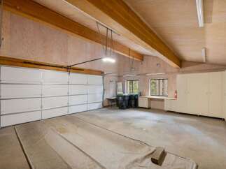 This spacious garage features a large, white overhead door, perfect for accommodating vehicles and ample storage.