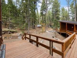 Experience the serene mountain lifestyle with this charming cabin nestled amidst towering pine trees.