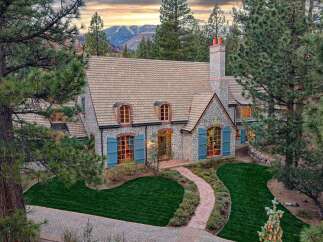 Nestled amidst towering pine trees and overlooking majestic mountains, this charming stone home offers a picturesque retreat.