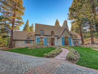Discover this stunning stone-clad residence nestled amongst mature pine trees, offering a picturesque setting.