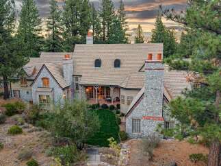 Nestled amidst towering pine trees, this magnificent stone and stucco residence offers unparalleled luxury and privacy.
