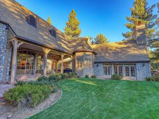 Experience luxury living in this stunning stone and wood-accented home, nestled amongst mature pine trees.