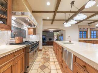 Experience luxury in this expansive gourmet kitchen, featuring a professional-grade stainless steel range and a striking copper pot.