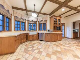 This spacious kitchen boasts charming wooden cabinetry and a large farmhouse sink, perfect for any home chef.
