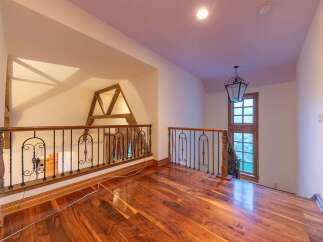 This spacious loft area boasts stunning hardwood floors that gleam under the ambient lighting.