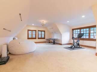 This spacious attic room offers a versatile layout, perfect for a home gym or a creative studio.