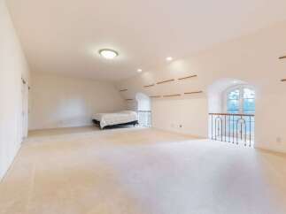 Discover this spacious loft bedroom featuring plush cream carpeting throughout, creating a warm and inviting atmosphere.