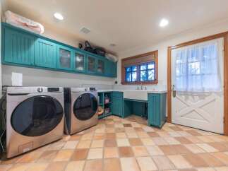 This spacious laundry room features two Samsung front-load washers, perfect for handling large loads.