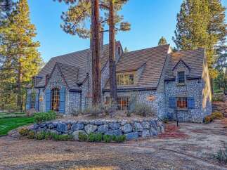 Discover this charming stone-clad home nestled amongst mature pine trees, offering a picturesque setting.