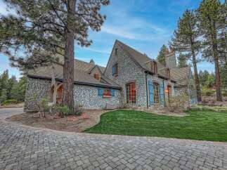 Experience luxury living in this stunning stone-clad residence, nestled amidst towering pine trees.