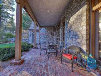Enjoy your morning coffee on this charming brick patio, complete with a wrought iron table and chairs, perfect for al fresco dining.