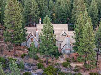 Nestled amidst a dense forest of towering pine trees, this magnificent stone-clad home offers a secluded mountain retreat.