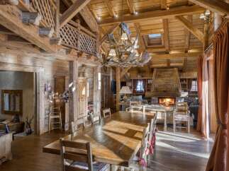 Experience rustic luxury in this stunning log cabin living and dining area.
