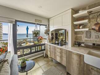 Experience breathtaking ocean views from this stunning kitchen, featuring a sleek induction stovetop and ample cabinet space.