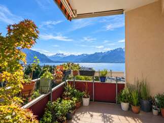 Experience breathtaking panoramic views from this stunning balcony, overlooking a serene lake and majestic snow-capped mountains.