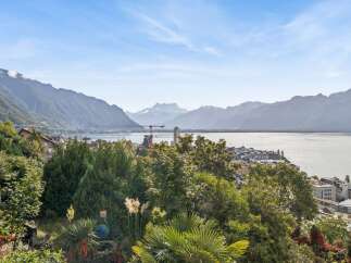 Experience breathtaking panoramic views of a serene lake and majestic mountains from this stunning property.