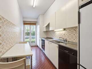 This kitchen features a dining area with a marble-top table and chairs, perfect for casual meals.
