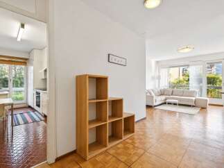 Discover this charming apartment featuring a bright and airy living space with a large sectional sofa and a modern coffee table, perfect for relaxation and entertaining.