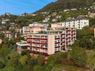 This modern apartment building offers stunning views of the surrounding hills and lush greenery.