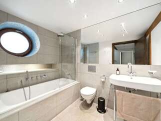 Experience modern luxury in this stunning bathroom, featuring a deep soaking tub perfect for relaxation and a sleek vanity with a chrome faucet.