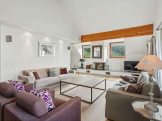 Experience modern living in this spacious living room, featuring a sleek fireplace and a large coffee table perfect for gatherings.