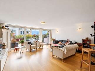 Experience luxurious living in this spacious apartment, featuring a large, open-plan living area with comfortable seating and a modern entertainment center.