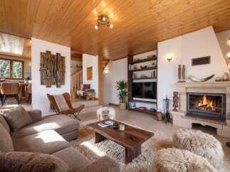 Experience rustic charm and modern comfort in this inviting living room, featuring a plush sectional sofa and a cozy fireplace perfect for gathering.