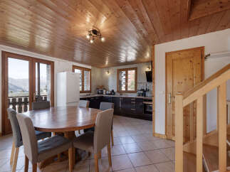This charming mountain home features a spacious dining area with a large wooden table and comfortable seating, perfect for family meals.