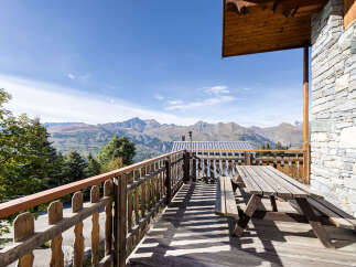 Enjoy breathtaking mountain views from this charming wooden balcony, complete with a picnic table perfect for al fresco dining.