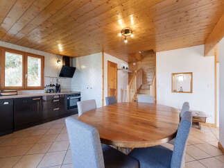 Experience rustic charm in this open-concept living space, featuring a warm wooden ceiling and walls that create a cozy, cabin-like atmosphere.