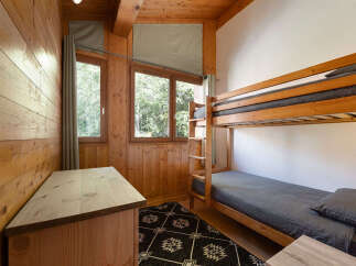 This charming bedroom features a cozy wooden bunk bed, perfect for families or guests.