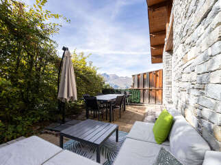 Enjoy breathtaking mountain views from this stunning outdoor living space, perfect for al fresco dining and relaxation.