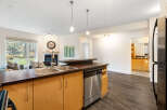 Experience modern living in this open-concept condo, featuring a sleek kitchen with a breakfast bar and stainless steel appliances.