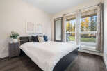Experience comfortable living in this inviting bedroom, featuring a plush white comforter on a dark wood bed frame.