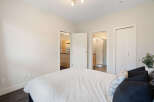 Step into this inviting bedroom, featuring a plush white comforter and a selection of decorative pillows.
