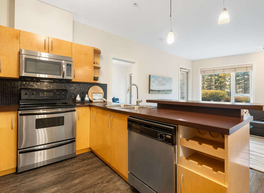 Discover this modern kitchen featuring sleek stainless steel appliances, including a microwave, oven, and dishwasher.