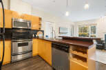 Discover this modern kitchen featuring sleek stainless steel appliances, including a microwave, oven, and dishwasher.