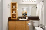 This modern bathroom features a sleek vanity with ample storage and a clean white sink, complemented by a dark countertop.